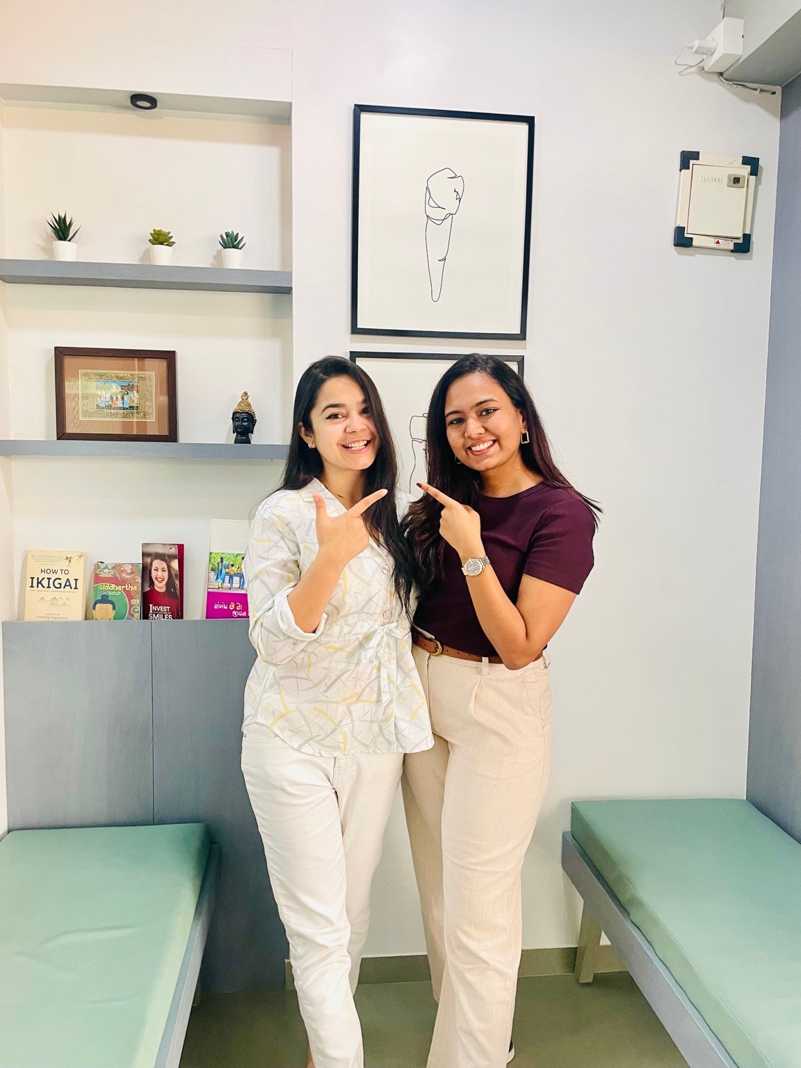 Two women smiling together in the Bliss Dental Studio waiting area